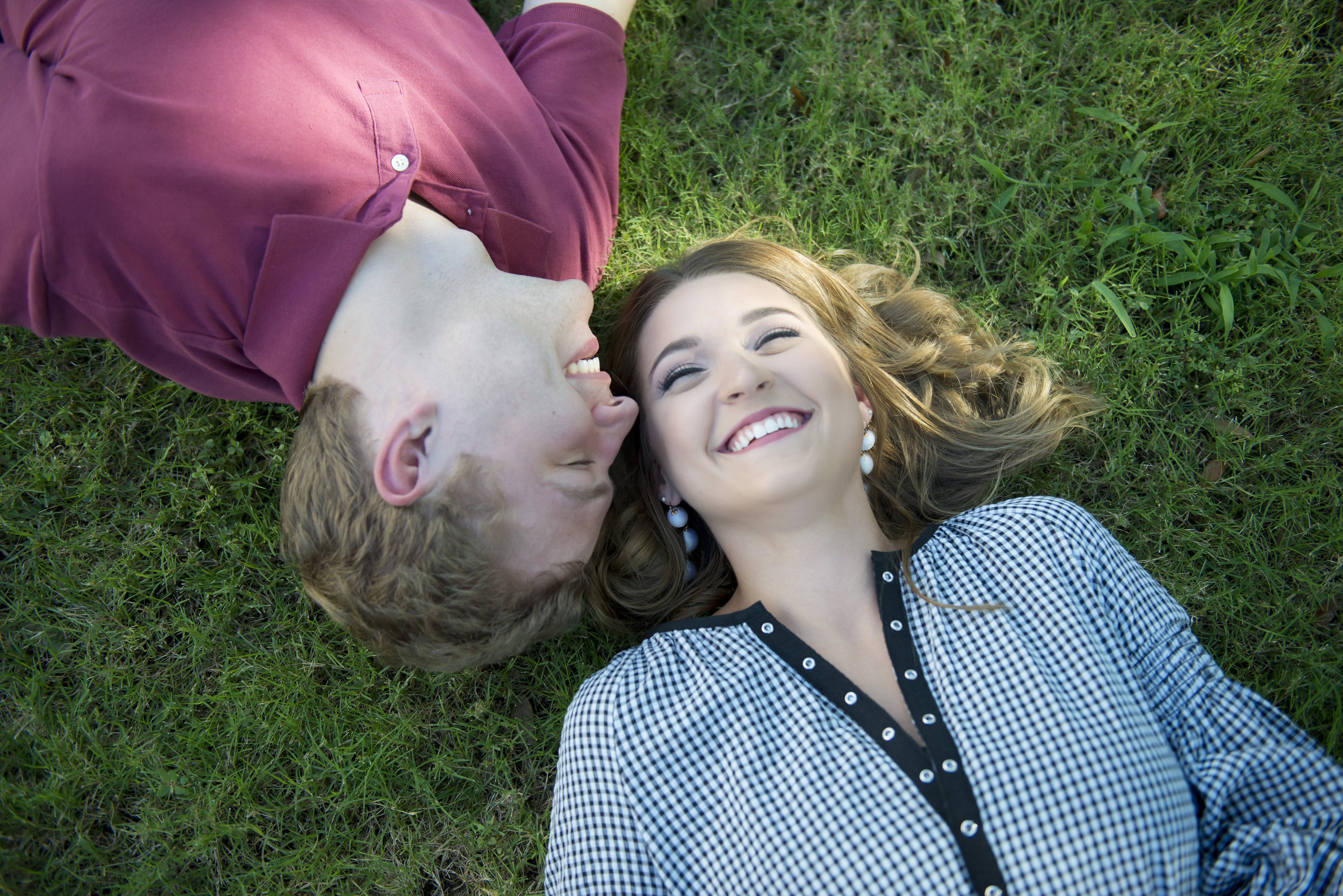 Couple Smiling and Laying on Grass