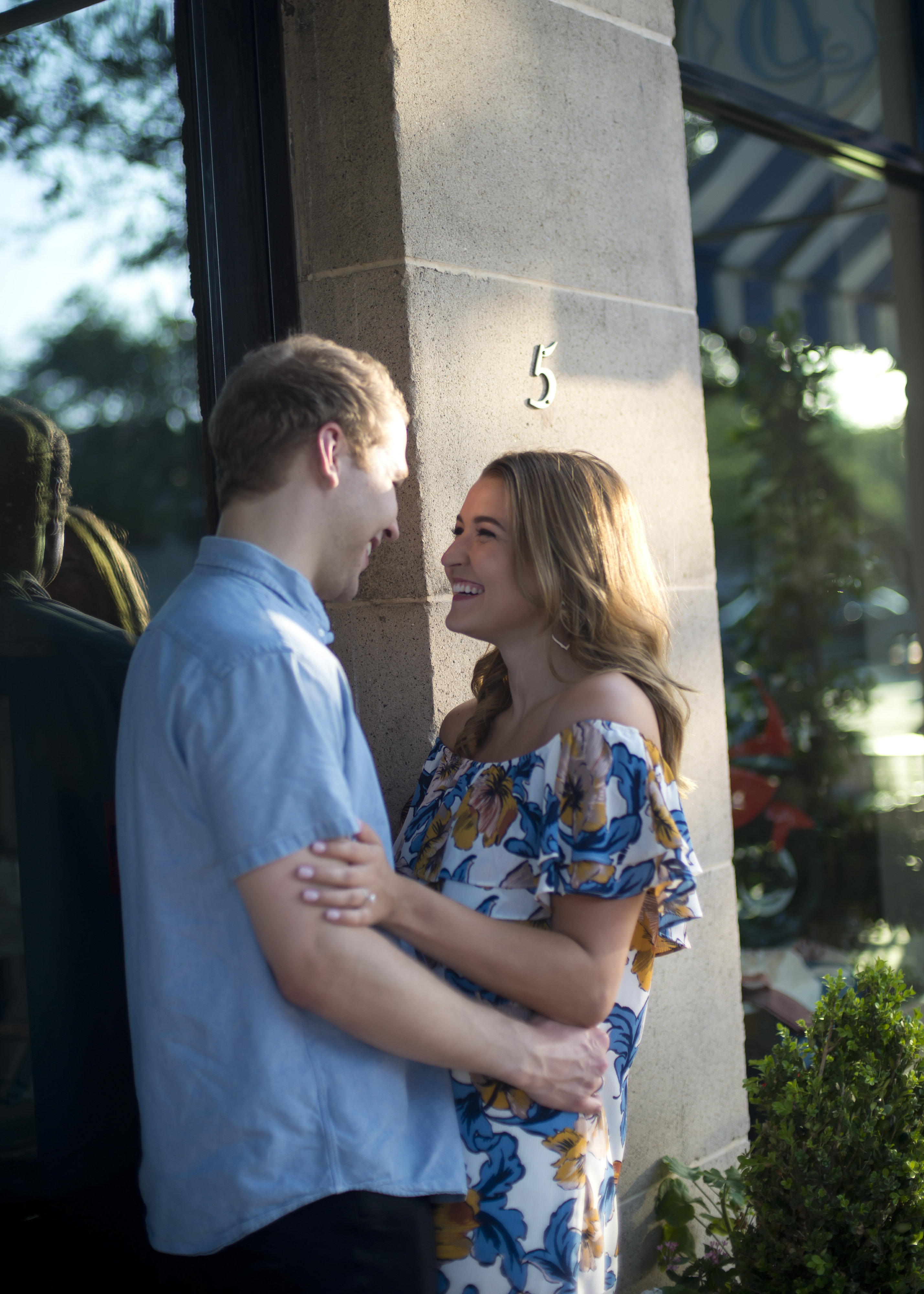 Couple Smiling Next to Building at Sunset