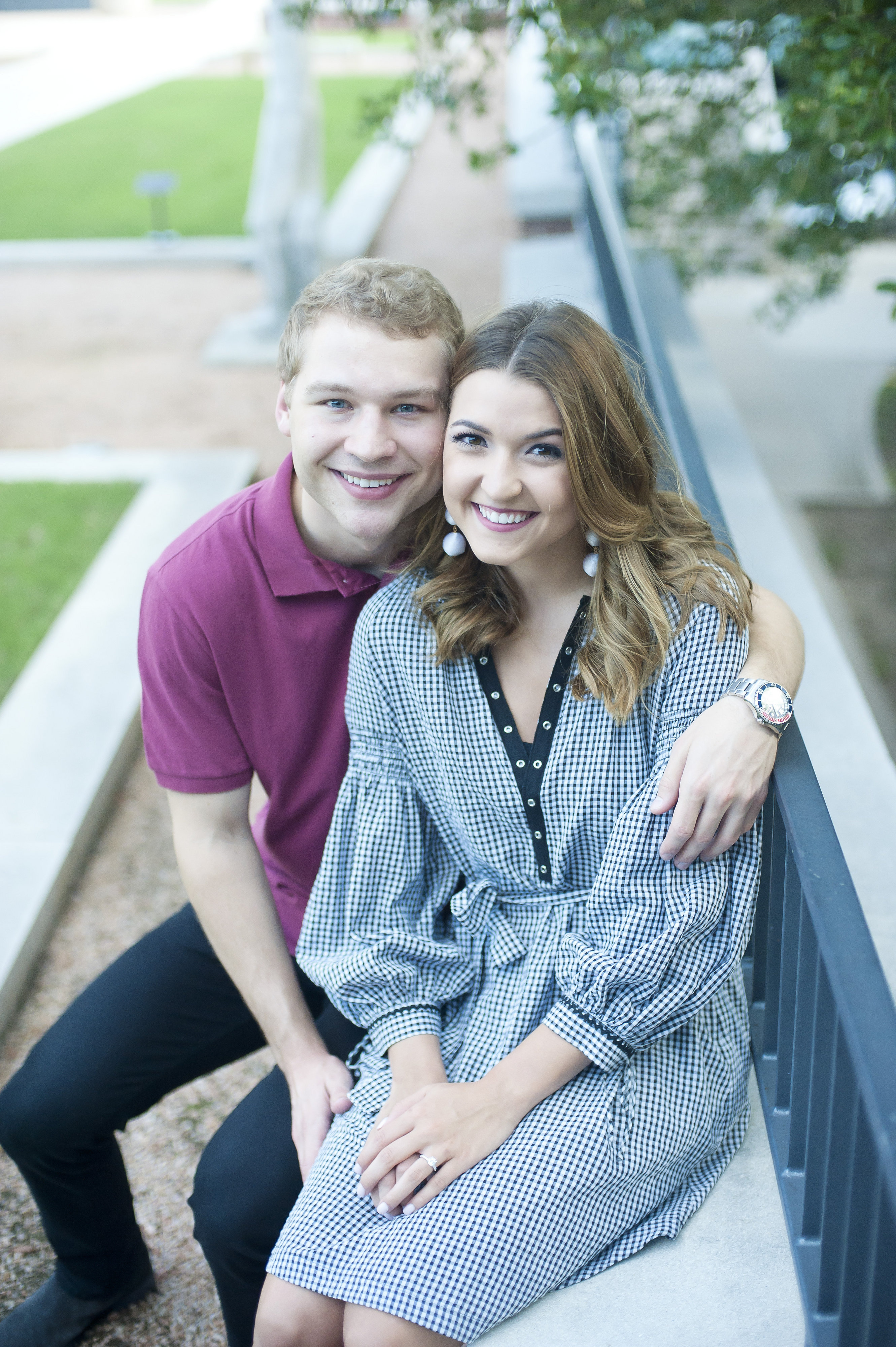 Couple Sitting Along Fence