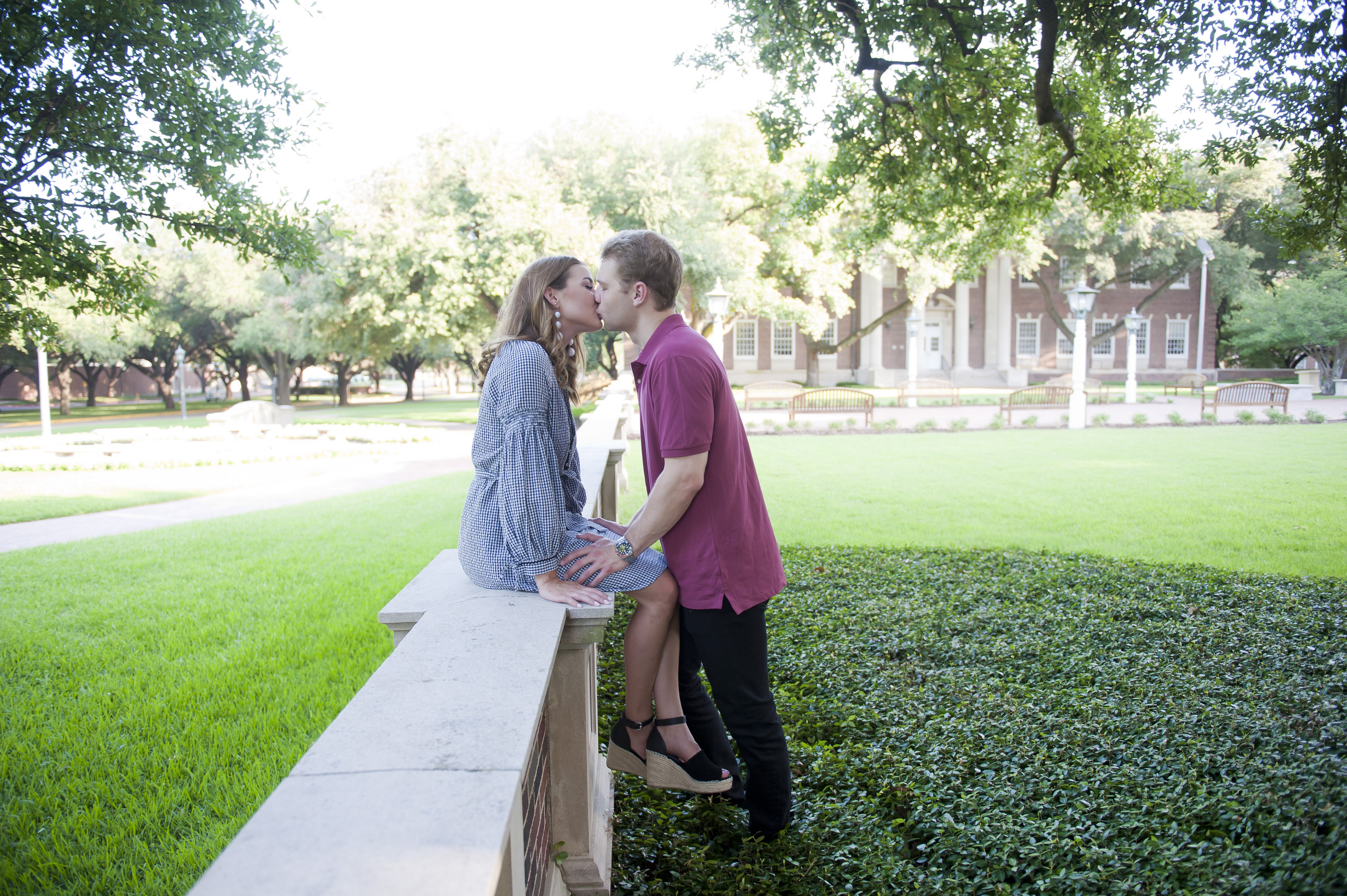 Couple Sitting and Kissing on Fence