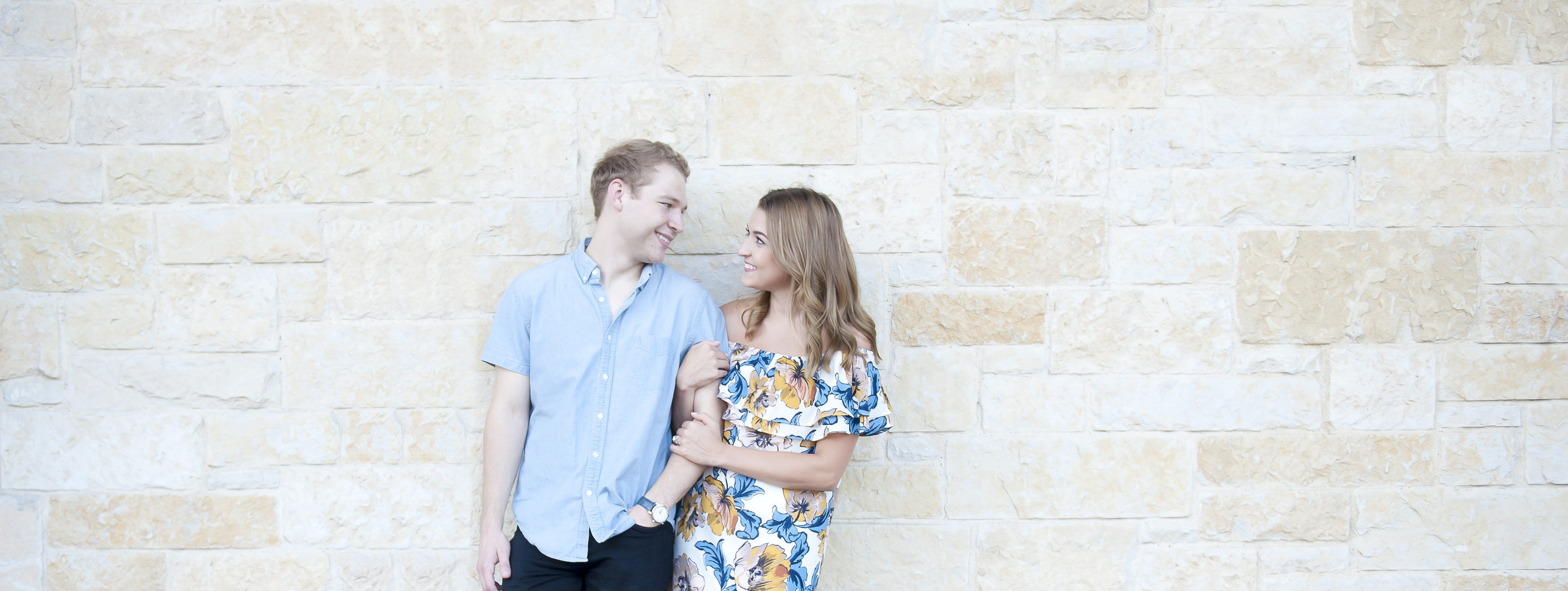 Couple Leaning on Austin Stone Wall